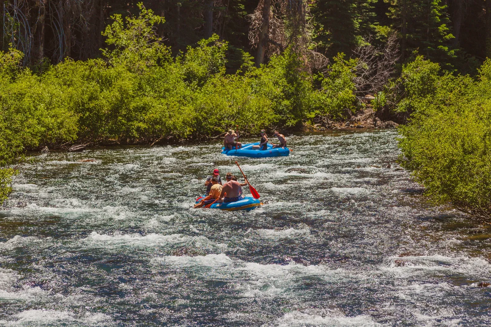 Rafts moving through a shaded section of the Truckee River