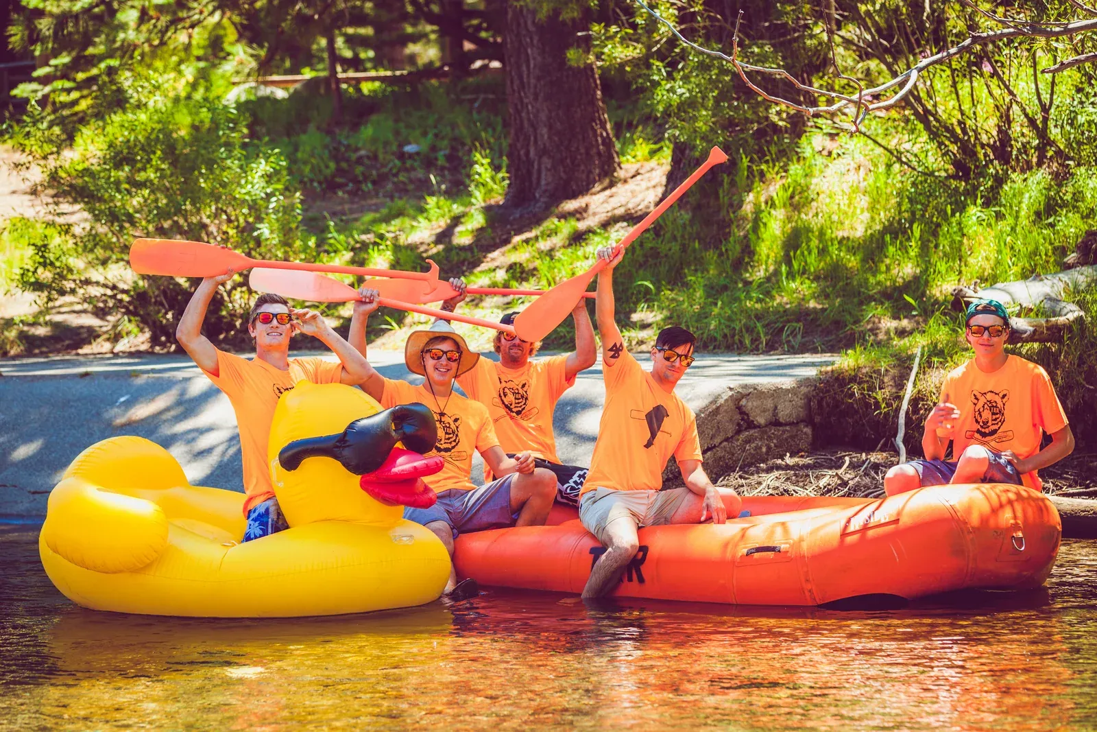 Guests floating together on the clear Truckee River beneath pine trees