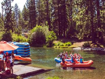 Blue and orange rafts launching from the dock at the Truckee River Raft Co. put-in in Tahoe City