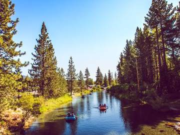 Guests paddling a raft through a rocky stretch of the Truckee River