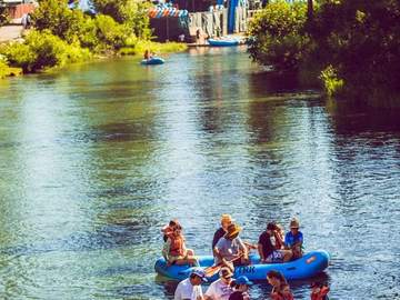 A loaded raft drifting the calm middle stretch of the Truckee River