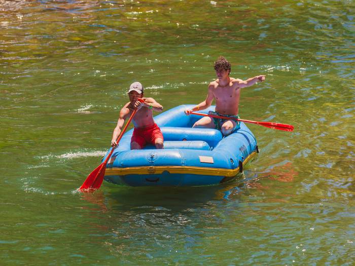 A young rafter paddling an inflatable raft down the Truckee River